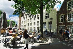 a group of people sitting at tables in a courtyard at Spacious Suite at Park and Museum in Amsterdam