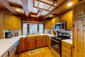 una cucina con mobili in legno e un forno a piano cottura di Eagle River Retreat a Eagle River