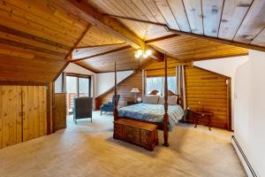 una camera da letto con un letto in una stanza con soffitti in legno di Eagle River Retreat a Eagle River