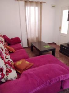 a purple couch in a living room with a table at Casa cris in Valencia