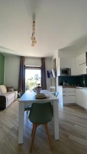 a living room with a white table and a kitchen at Torre Di Mare Home in Scalea