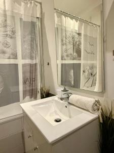 a white bathroom with a sink and a mirror at Family Champs Elysées appartement in Paris