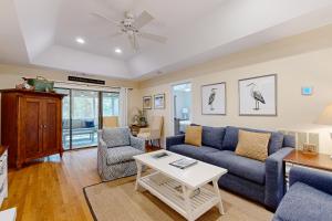 a living room with a blue couch and a table at Inlet Cove 11 in Kiawah Island