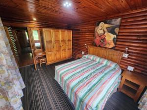 a bedroom with a bed in a wooden cabin at Plettenberg, a Forever Resort in Plettenberg Bay