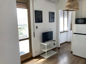 a living room with a television on a white table at Monolocale con ampio terrazzo in Milan
