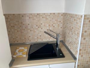 a kitchen counter with a sink in a tiled wall at Monolocale con ampio terrazzo in Milan +29 photos