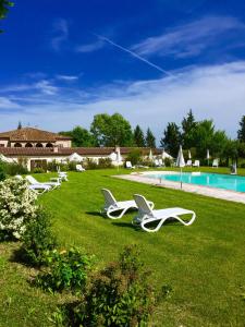 a group of lawn chairs sitting in the grass by a pool at Il Canto del Sole in Monteroni dʼArbia