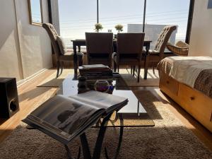 a living room with a table and a bed and a table and chairs at Departamento con Vista al Mar en Pichilemu in Pichilemu