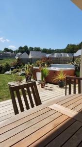 a wooden deck with two benches and plants at La Régate du Plaisir- Jacuzzi privé, Plage à 900m in Houlgate