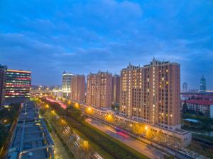 une ville avec de nombreux bâtiments hauts et des lumières de rue dans l'établissement Green Court Place Jingqiao Middle Ring Shanghai, à Shanghai