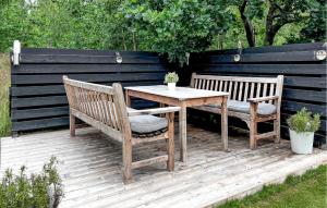 恩厄尔霍尔姆Klitterbyn 16的一张桌子和两条长凳摆放在木制平台上。