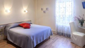 En eller flere senger på et rom på Logis Hôtel le Clos du Vigneron