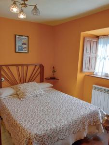 une chambre avec un lit avec une couette blanche dans l'établissement Casa de Aldea La Pescal, à La Pescal