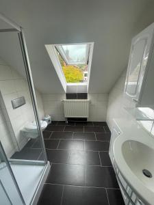 a bathroom with a toilet and a sink and a window at Ferienwohnung Ludwig in Karlstadt