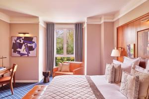 a hotel room with a bed and a desk and a window at Hôtel Barrière Le Westminster in Le Touquet-Paris-Plage