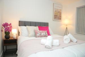a bedroom with a white bed with towels on it at Luxury Private Ensuite and Kitchenette Room Near Luton Airport 4 Min Drive in Luton