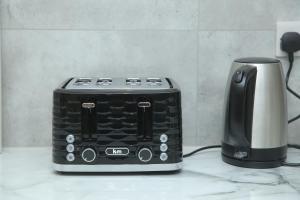 a toaster and a coffee maker on a counter at Luxury Private Ensuite and Kitchenette Room Near Luton Airport 4 Min Drive in Luton