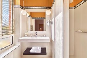 a bathroom with a sink and a mirror at Hôtel Barrière Le Westminster in Le Touquet-Paris-Plage