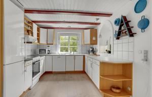 a kitchen with white cabinets and a window at Gorgeous Home In Ulfborg With Wifi in Ulfborg