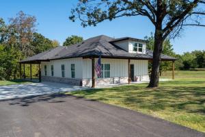 a house with a flag in front of a driveway at Brand New Modern Getaway on Private Land! in Tulsa