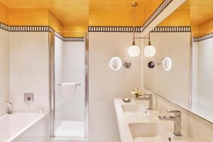 a bathroom with a sink and a shower at Hôtel Barrière Le Westminster in Le Touquet-Paris-Plage