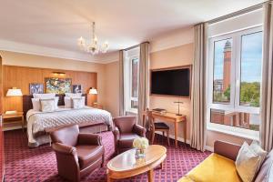 a hotel room with a bed and a tv at Hôtel Barrière Le Westminster in Le Touquet-Paris-Plage