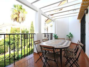 a patio with a table and chairs on a balcony at Valparaiso Apartment Burriana Beach in Nerja