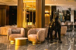un vestíbulo con una estatua de un perro y sillas en Hotel Royal Plovdiv, en Plovdiv
