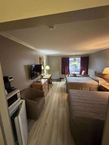 a hotel room with two beds and a television at Hôtel Motel Le Voyageur in Saint-Georges +27 photos