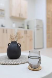 un vaso en un posavasos junto a un jarrón en una mesa en Kendall Luxury, en Arrecife