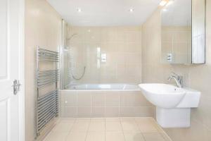 ein Badezimmer mit Badewanne, Waschbecken und Dusche in der Unterkunft 5-Bed Family Retreat in Chiswick in London + 8 Fotos