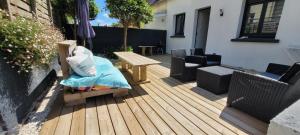a wooden deck with a wooden table and chairs at maison cosy in Quimper