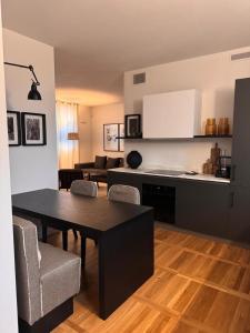 a kitchen and living room with a table and chairs at La suite in Piazza in Erbusco