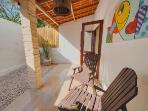 two chairs sitting on a porch with a painting on the wall at Pousada Melgaço in Icaraí