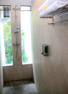 a shower stall in a bathroom with a window at Delu Villas & Suite in Kerobokan