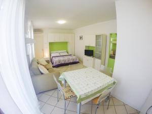- un salon avec un canapé et un lit dans l'établissement Residence Solemar - Agenzia Cocal, à Caorle