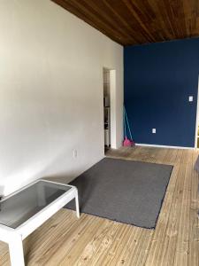 a living room with a table and a blue wall at Hostel Baía Sul Apenas para Mulheres in Florianópolis +18 photos