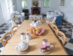 a wooden table with a plate of pastries on it at Les Bergeronnettes in Camors