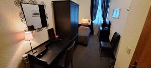 a room with a desk with a mirror and a bed at Parkhotel Essen in Essen