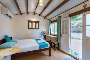 Ένα ή περισσότερα κρεβάτια σε δωμάτιο στο Palmeiral -BeachCottages