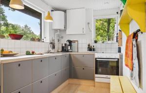 a kitchen with white cabinets and a window at Stunning Home In Ebeltoft With Kitchen in Ebeltoft