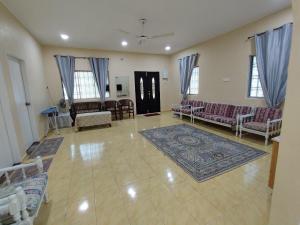 Yong PengにあるHomestay MakTehのソファ、テーブル、窓付きの広いリビングルーム
