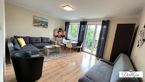 a living room with a couch and a table at W Dablju - Apartementy nad morzem in Władysławowo