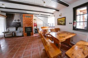 a room with wooden tables and benches and a fireplace at Ostoja Poleska in Kołacze