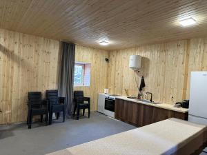 una cucina con pareti e sedie in legno e un frigorifero di Arde a Mestia