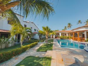a villa with a swimming pool and palm trees at Pousada Melgaço in Icaraí