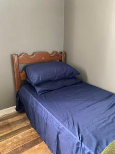 a bed with blue sheets and a wooden headboard at Hostel Baía Sul Apenas para Mulheres in Florianópolis