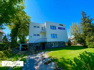 a large white building with stairs in a yard at W Dablju - Apartementy nad morzem in Władysławowo