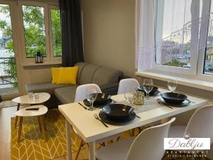 a living room with tables and chairs and a couch at W Dablju - Apartementy nad morzem in Władysławowo