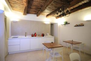 une cuisine avec des armoires blanches et une table et des chaises dans l'établissement Ai 13 Gradoni di Chiaia, à Naples 20 autres photos
